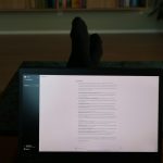 a person's feet resting on a computer screen